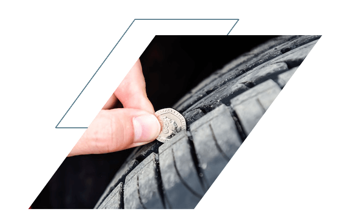 Person using 20p coin to test tyre tread depth