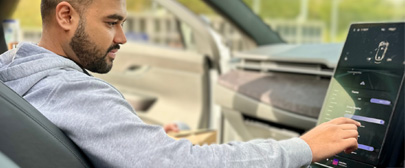 person using the touch screen in a car
