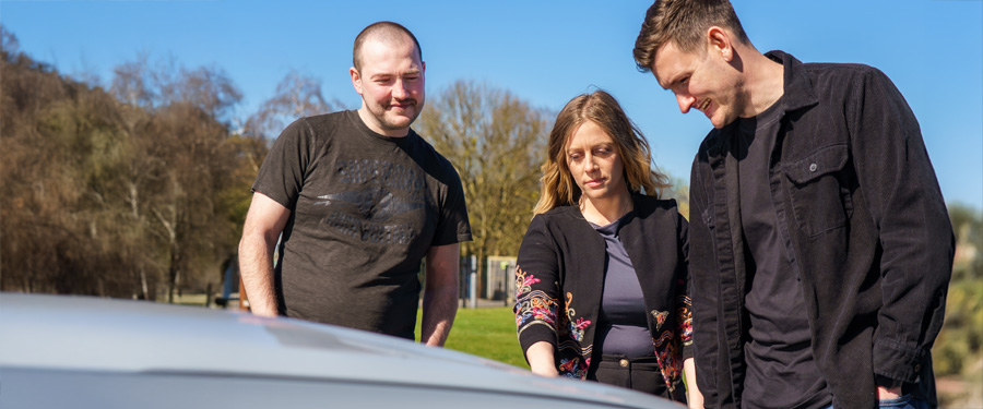 people discussing and look at the car.