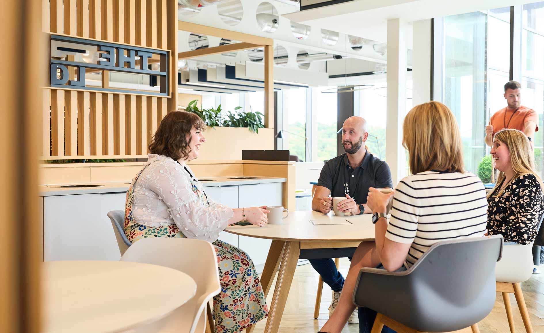 Staff around a table chatting