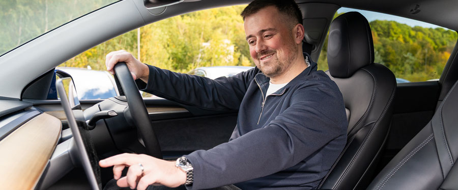 Man sat in the front seat using car interface.