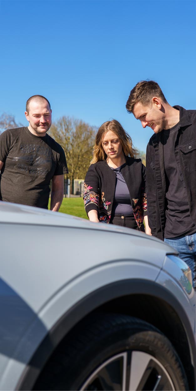 people looking at a car