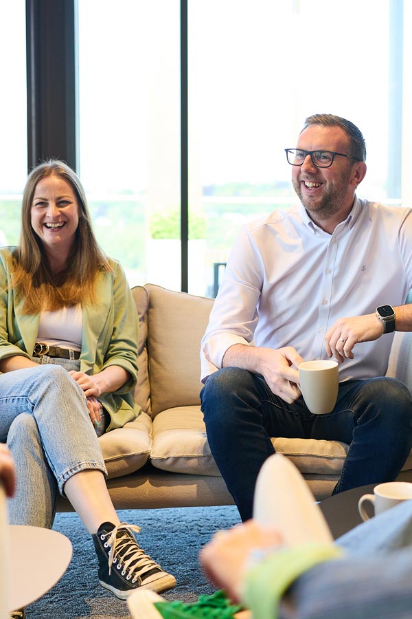 People sitting on a sofa chatting.