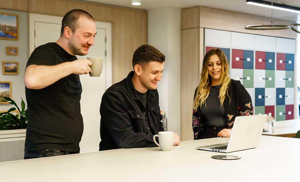 staff looking at a screen discussing work.