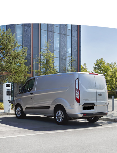 Van charging outside office building.